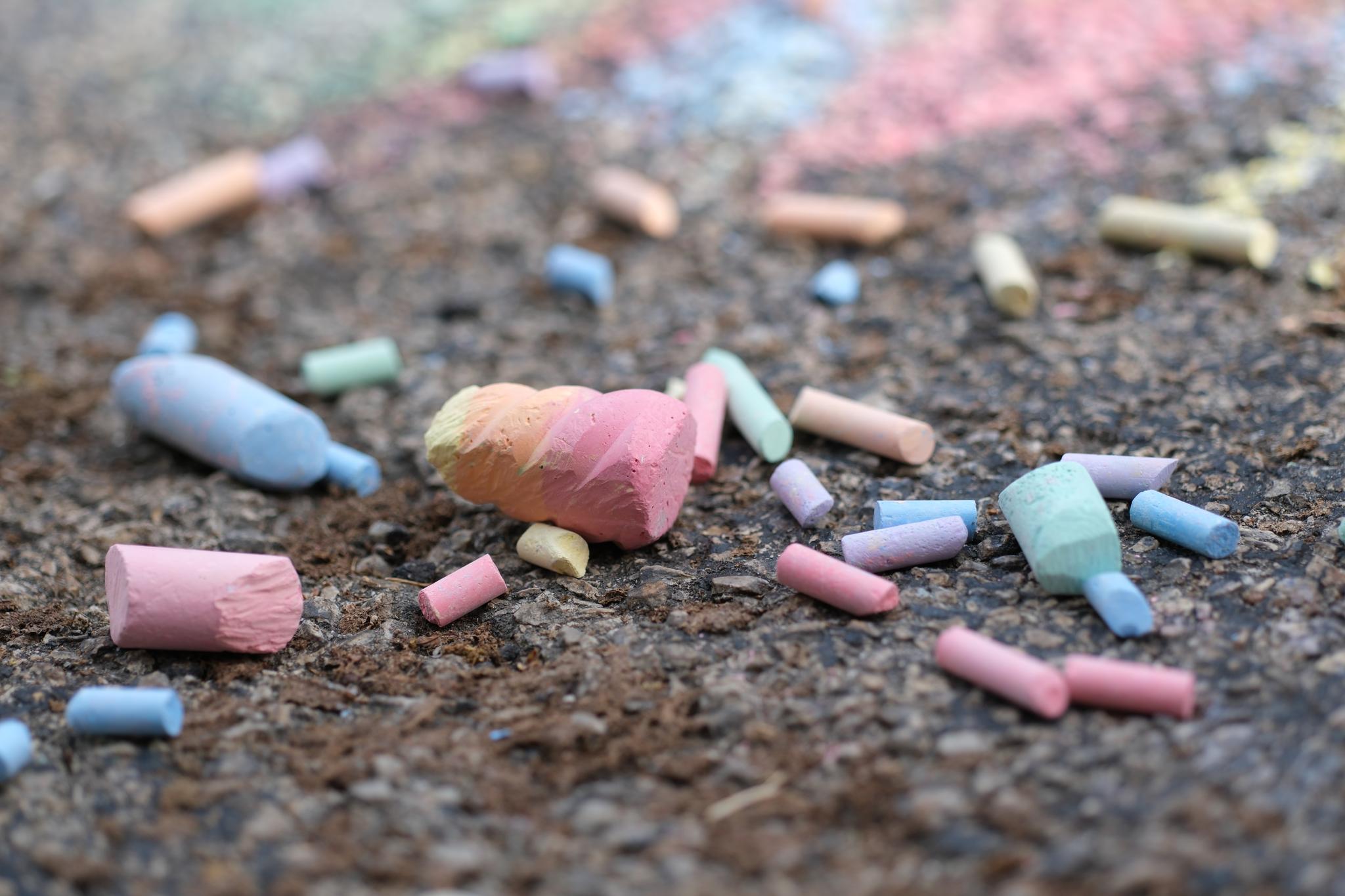 Scattered pieces of colorful chalk on a textured ground