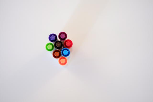 A cluster of colorful markers arranged in a circular pattern on a white background, viewed from above