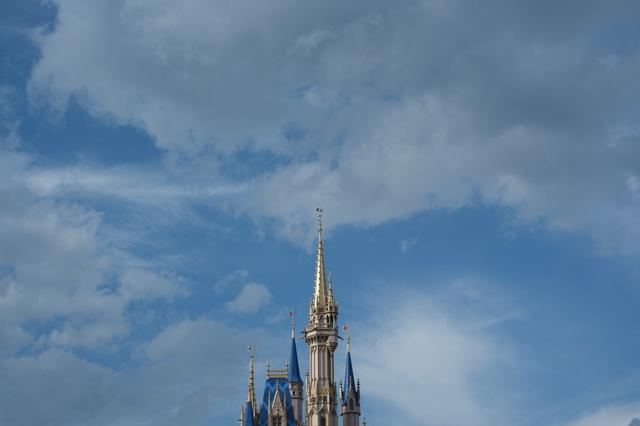A spire against a cloudy blue sky, likely part of a historic or iconic structure