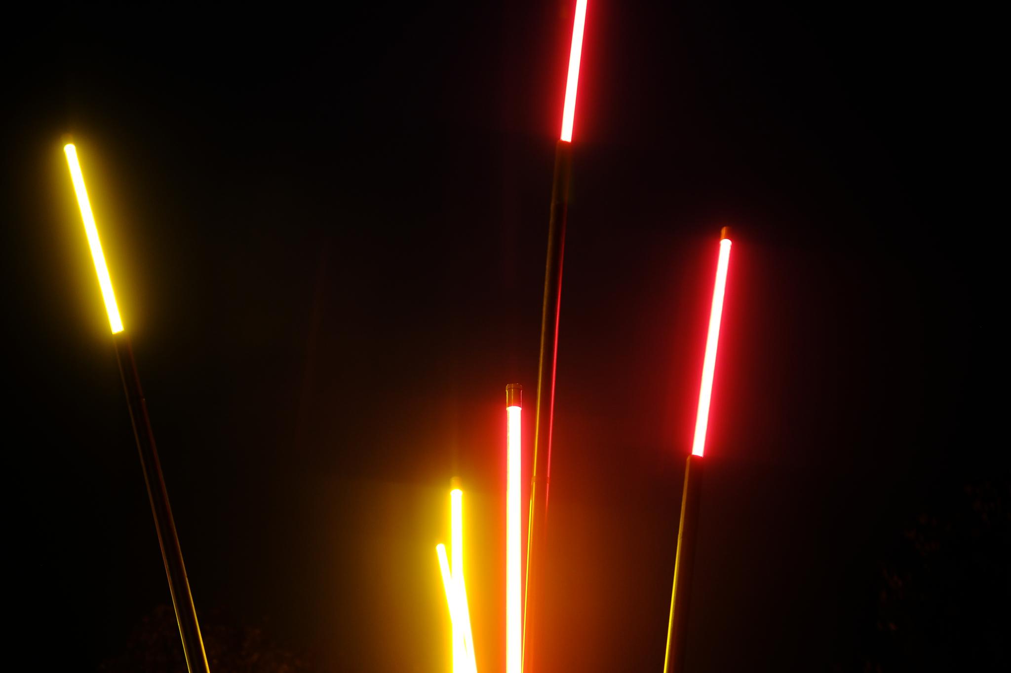 Bright, colorful light trails in red and yellow against a dark background