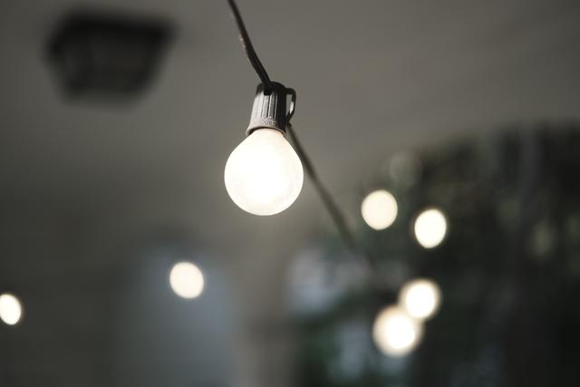 A close-up of a string light bulb with several other blurred lights in the background, creating a bokeh effect