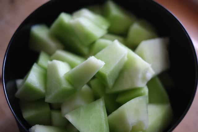 A bowl filled with cubed pieces of green melon