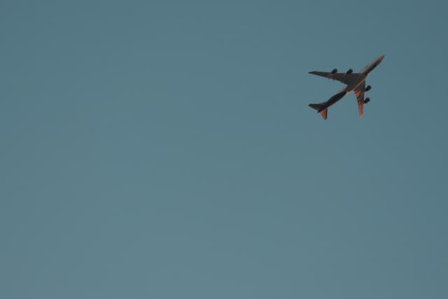 A large airplane flying against a clear blue sky