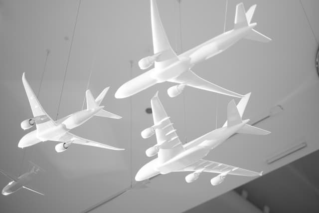 Several white airplane models suspended from the ceiling in a display setting