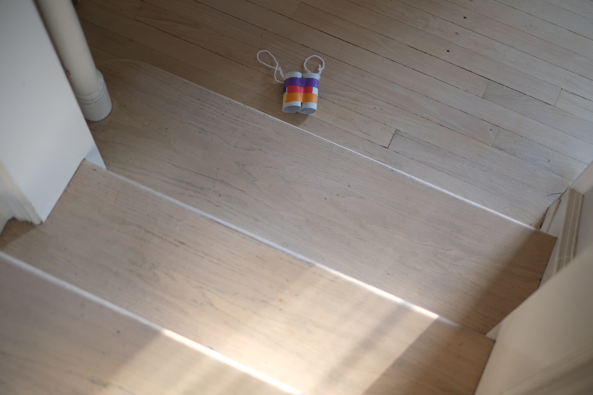 A wooden staircase with a colorful slinky toy at the top