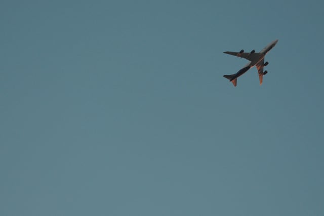 A large airplane flying against a clear blue sky