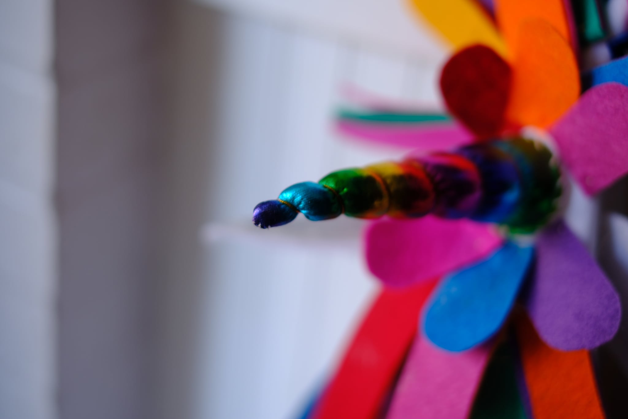 A colorful pinwheel with blurred petals, focusing on the tip against a soft background