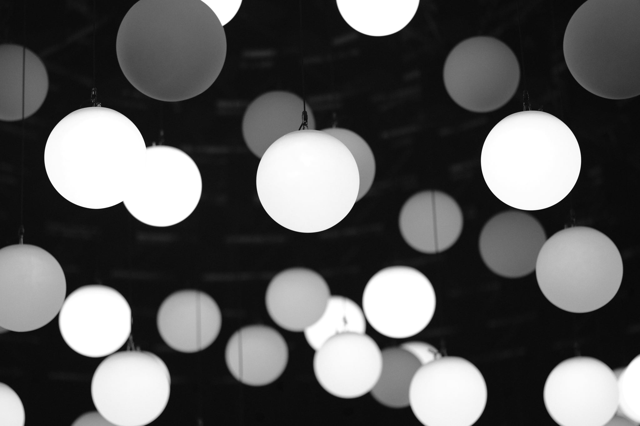 Abstract black-and-white bokeh lights with soft circular highlights on a dark background