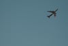 A large airplane flying against a clear blue sky